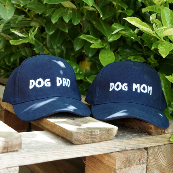 Dvije tamno plave šilter kape s natpisima Dog Dad i Dog Mom